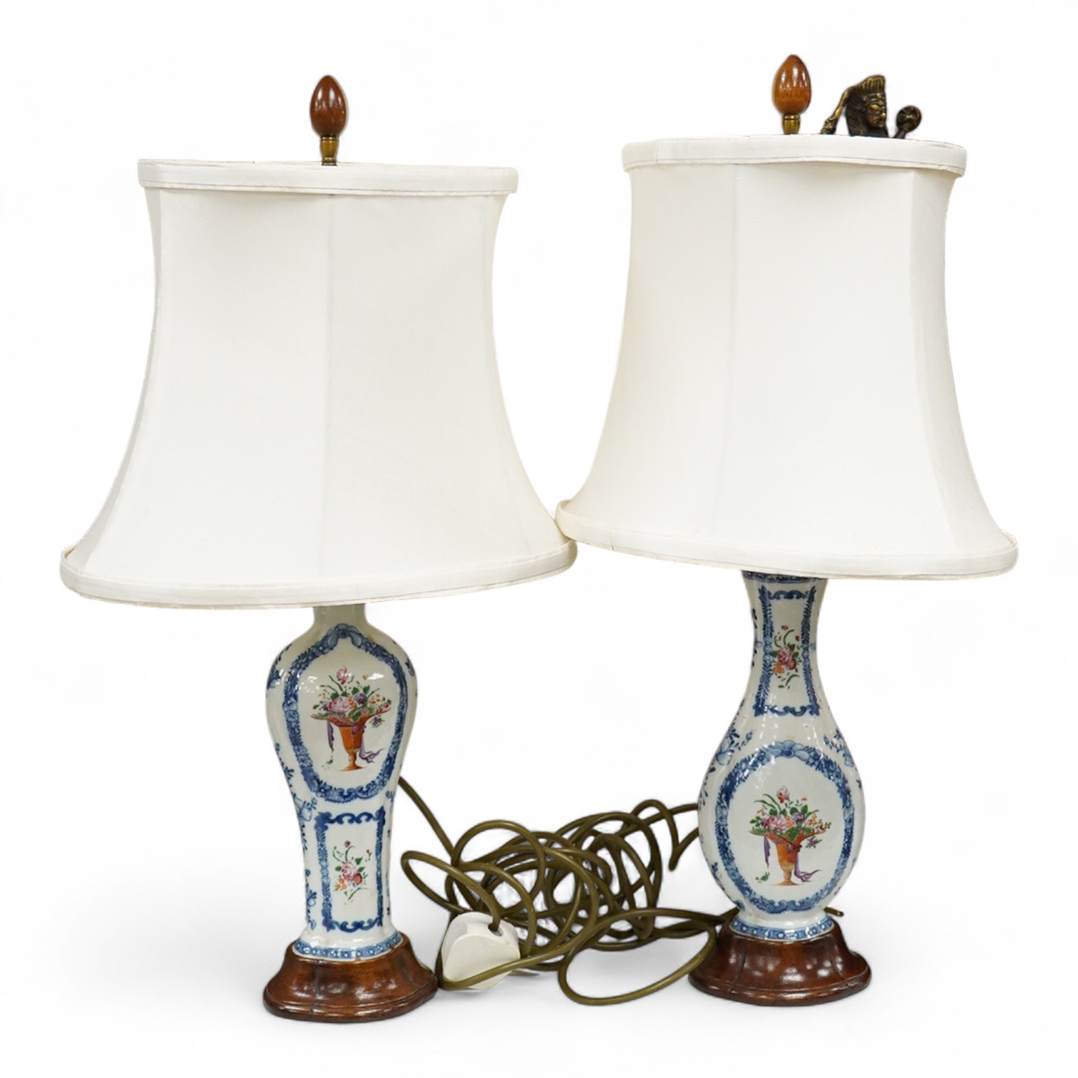 Two Chinese famille rose vases from a garniture, Qianlong period (1736-95), mounted as table lamps with shades, raised on shaped wood bases, overall 62cm high
